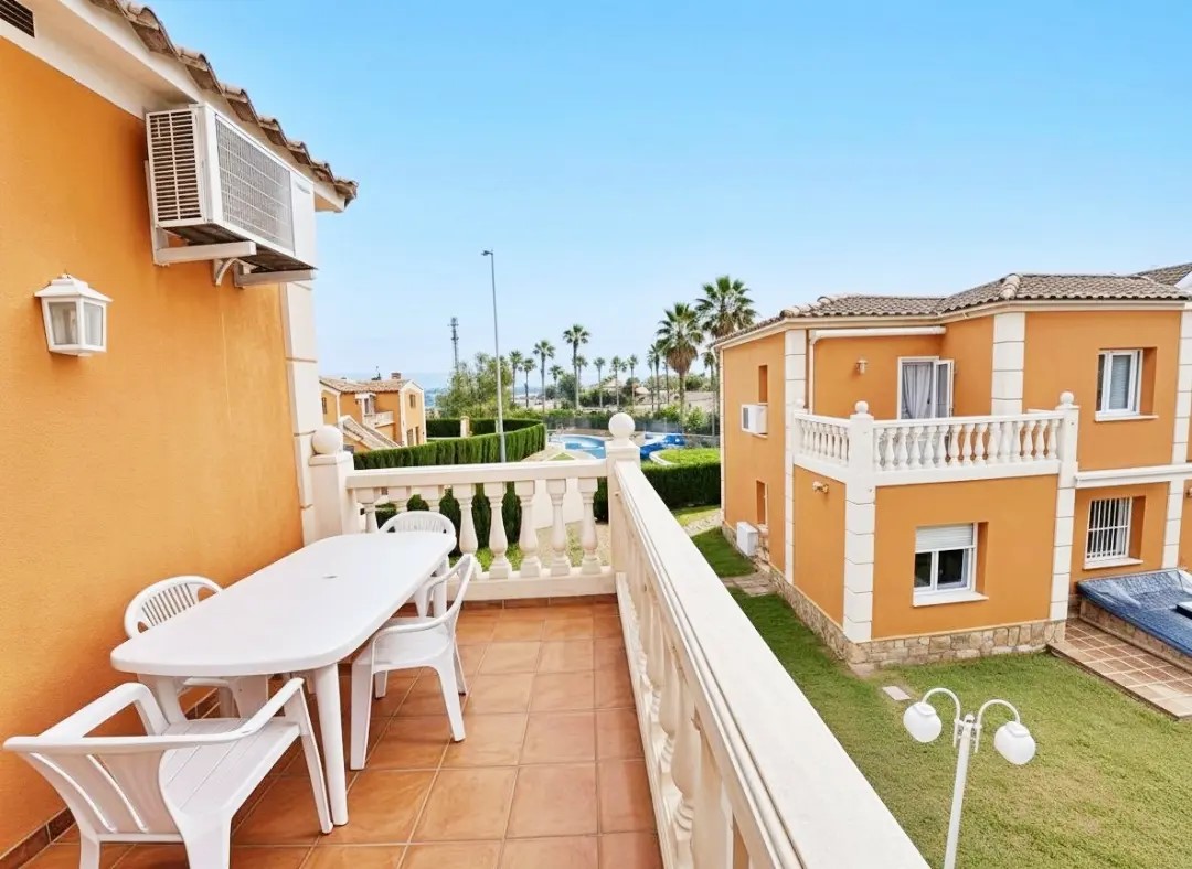 Terraza real del apartamento con mesa exterior y vistas a la urbanización